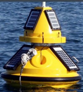 Solar-powered ocean buoy equipped with solar panels and sensors floating on calm sea waters under a partly cloudy sky, used for autonomous maritime monitoring.