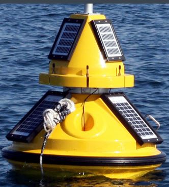 Solar-powered ocean buoy equipped with solar panels and sensors floating on calm sea waters under a partly cloudy sky, used for autonomous maritime monitoring.